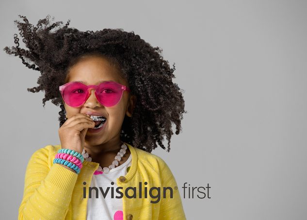 A child is using Invisalign First clear aligners for early interceptive phase 1 treatment.