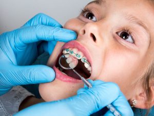 Child with braces has her mouth checked by an orthodontist.